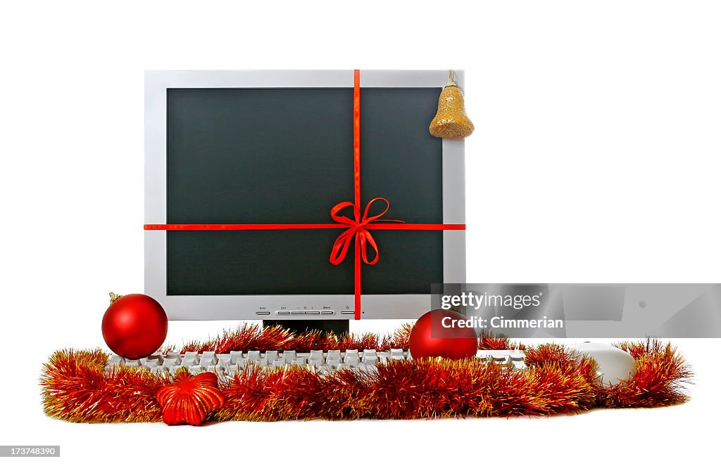 Computer decorated with ribbon, balls and tinsel. Isolated on white.
